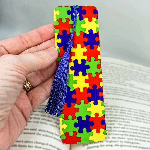 a person holding a bookmark made out of puzzle pieces