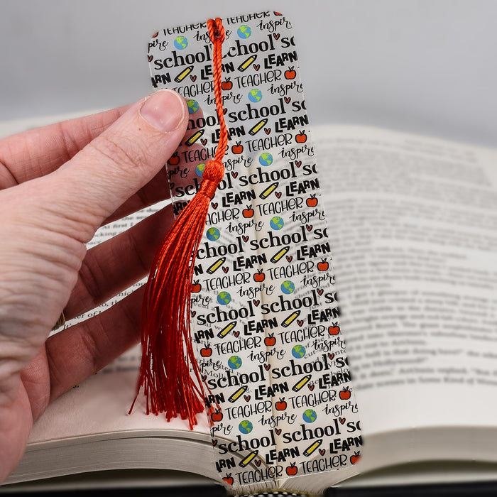 a person is holding a bookmark in their hand