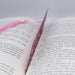 an open book with a pink thread on top of it