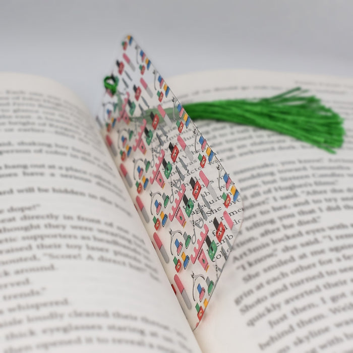 an open book with a green tassel on top of it