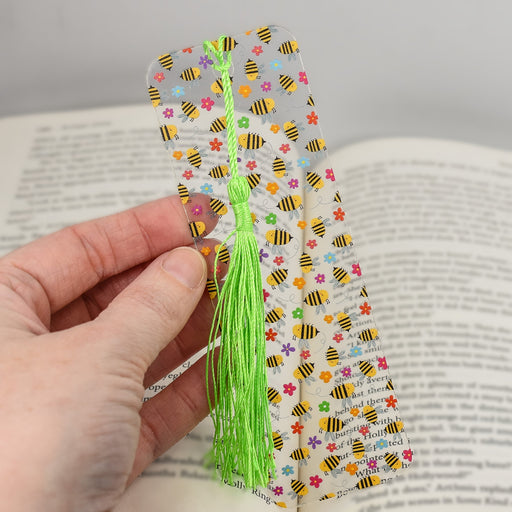 a person is holding a bookmark with a tassel