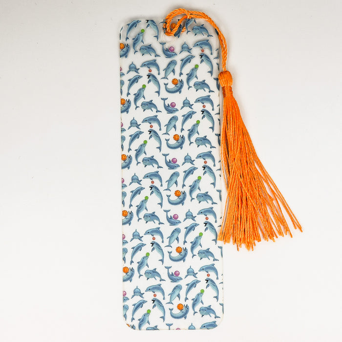 a bookmark with dolphins and orange tassels