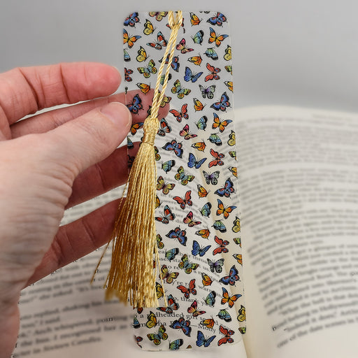 a hand holding a bookmark with butterflies on it