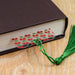 a book with a green tassel on top of it