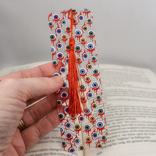 a person is holding a bookmark made out of paper