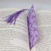 an open book with a purple tie on top of it