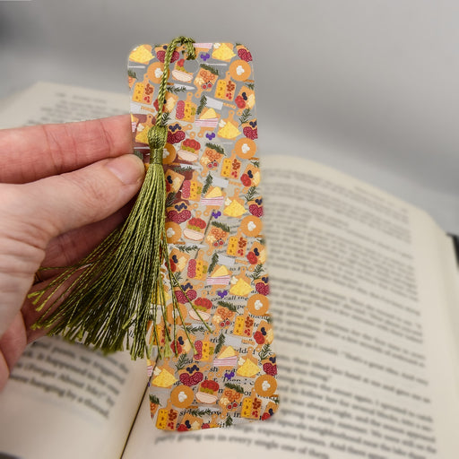 a person holding a bookmark with a book in the background