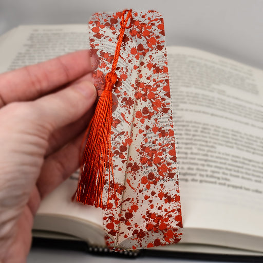 a person is holding a book with a tassel on it