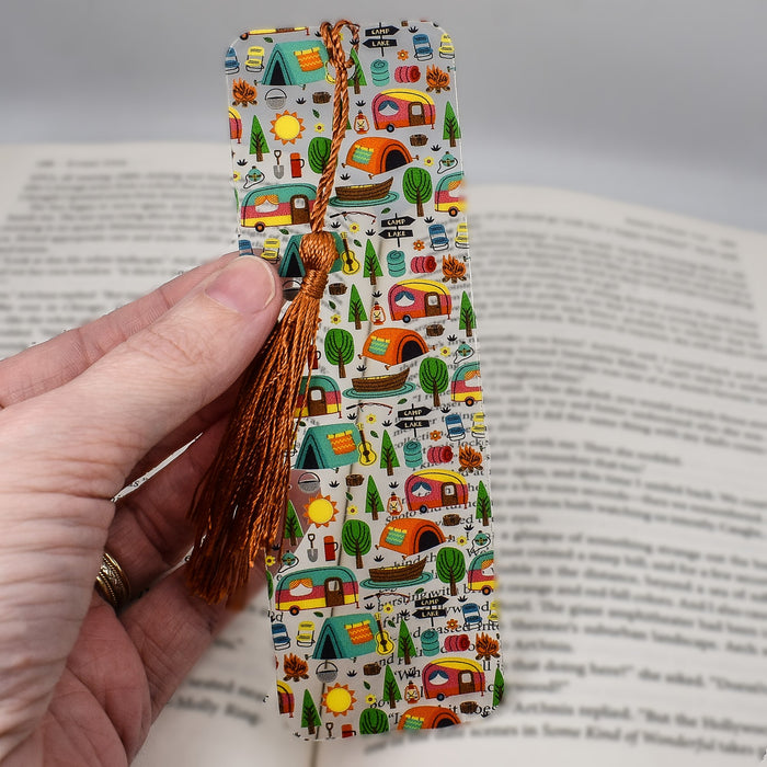 a hand holding a bookmark with a tie on it