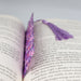 an open book with a purple tassel on top of it