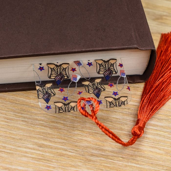 a book with a red tassel and a pair of glasses