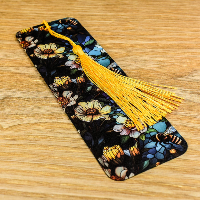 a phone case with a yellow tassel on a wooden table