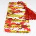 a tie with a red tassel on top of it