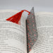 an open book with a red tassel on top of it