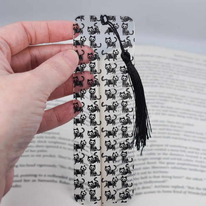 a person is holding a bookmark with skulls on it