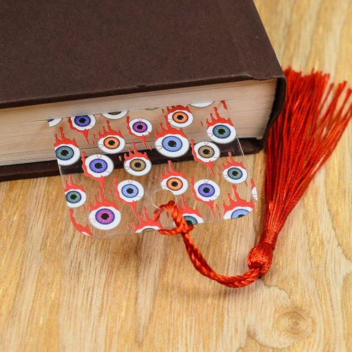 a book with eyeballs and a tassel on top of it