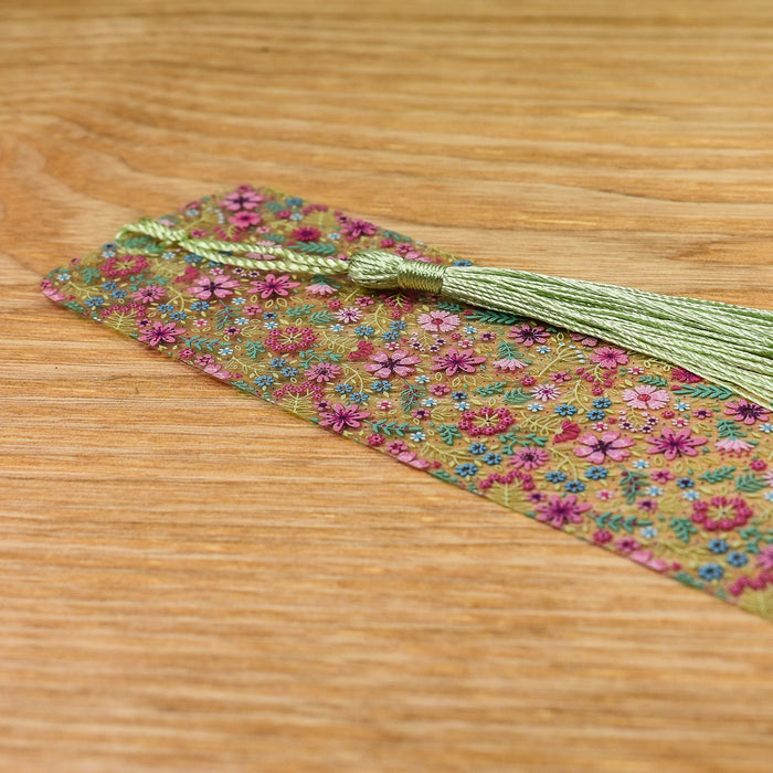 a tie with a green tassel on a wooden table