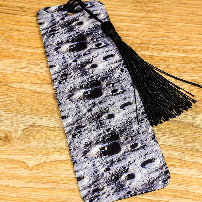 a bookmark with a tassel on top of a wooden table