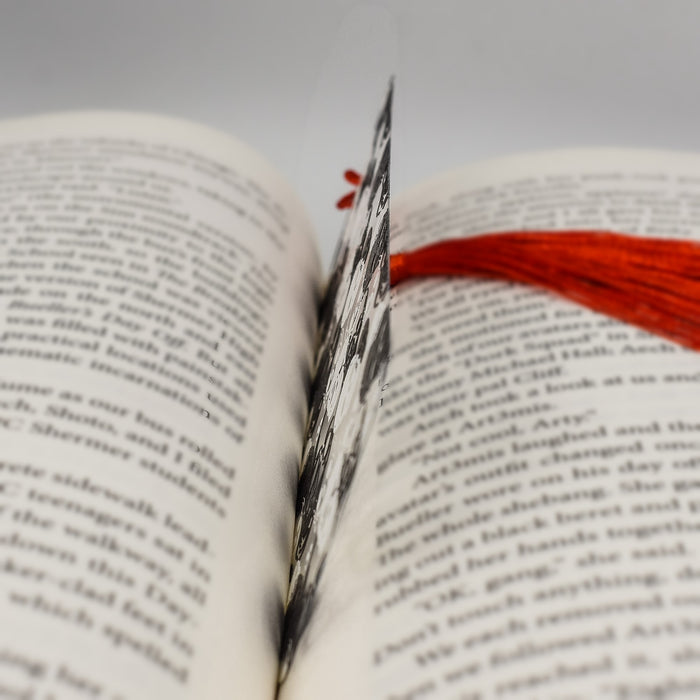 an open book with a red tassel on top of it
