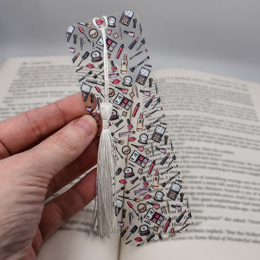 a hand holding a bookmark made out of a book