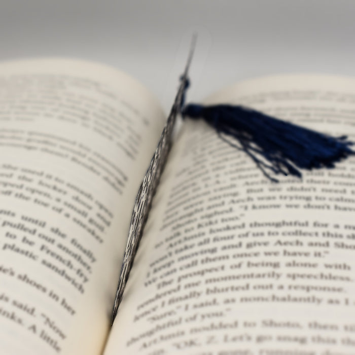 an open book with a tassel on top of it