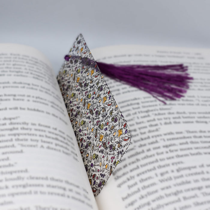 an open book with a purple tassel on top of it