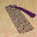 a tie on a wooden table with a purple tassel