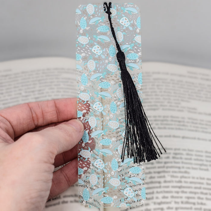 a person holding a bookmark with a tassel on it