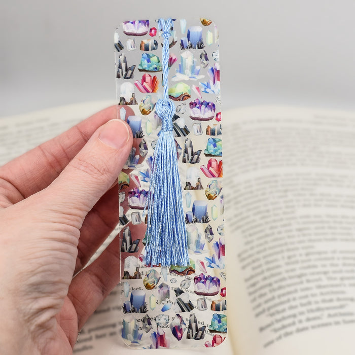 a person holding a bookmark with a book in front of it