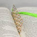 an open book with a green tassel on top of it