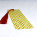 a yellow tie with a red tassel on it