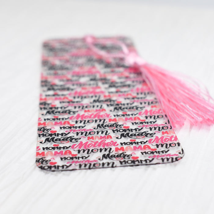 a pink tasseled bookmark laying on a white surface