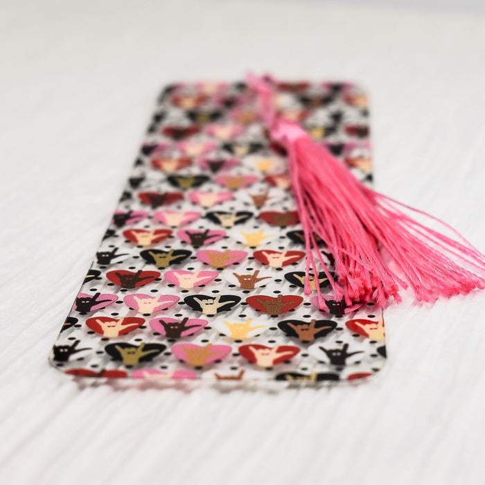 a pink tasseled bookmark laying on top of a white table