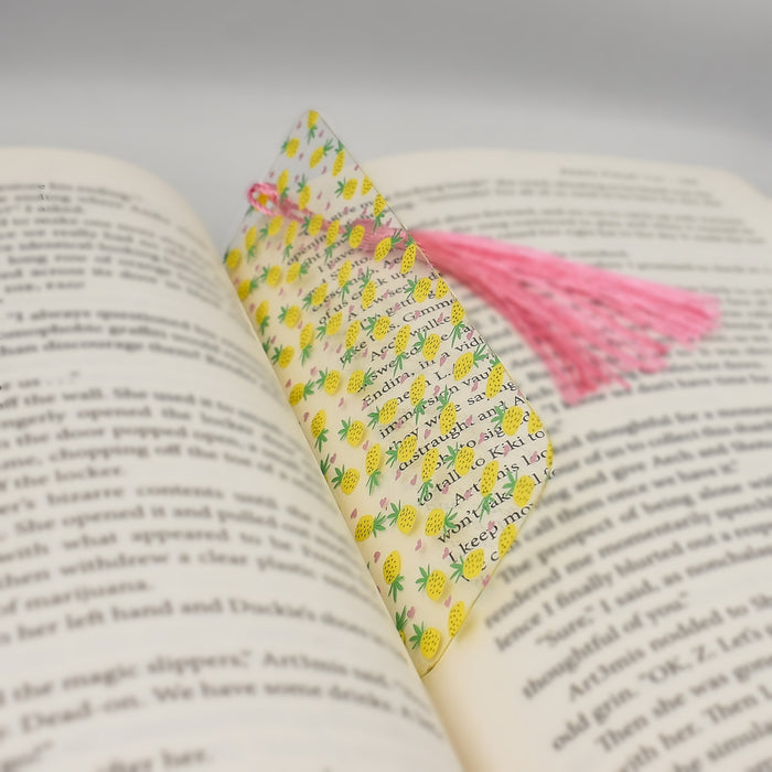 an open book with a pink tassel on top of it