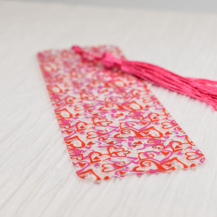 a pink and red tie laying on top of a bed