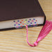 a book with a pink tassel on top of it