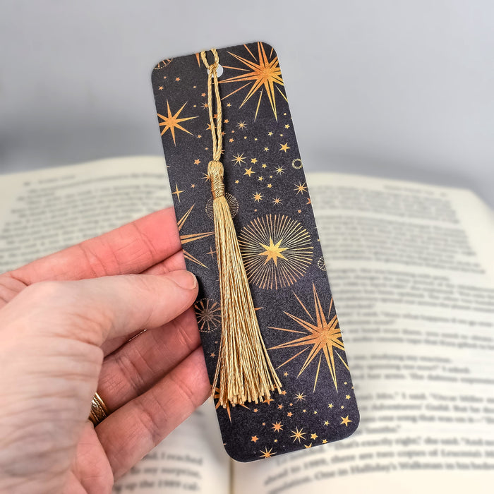 a hand holding a bookmark with a tassel