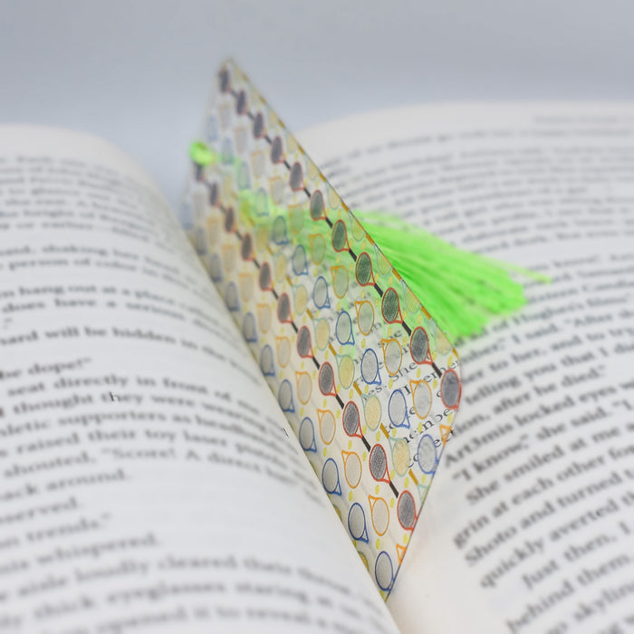 an open book with a green tassel on top of it