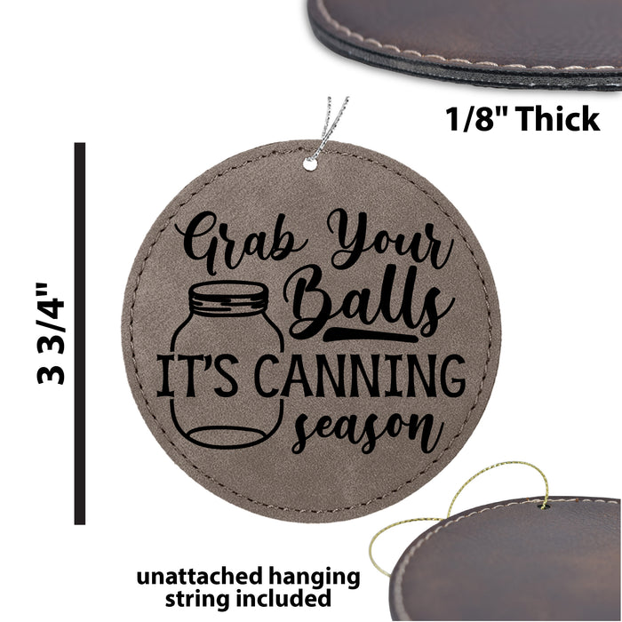 a leather ornament with the words grab your balls it's canning season