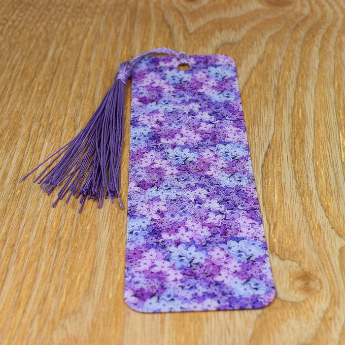 a purple and blue bookmark with a tassel on a wooden table