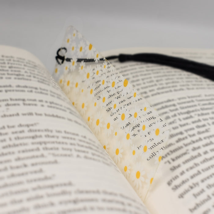 an open book with a black ribbon and yellow dots on it