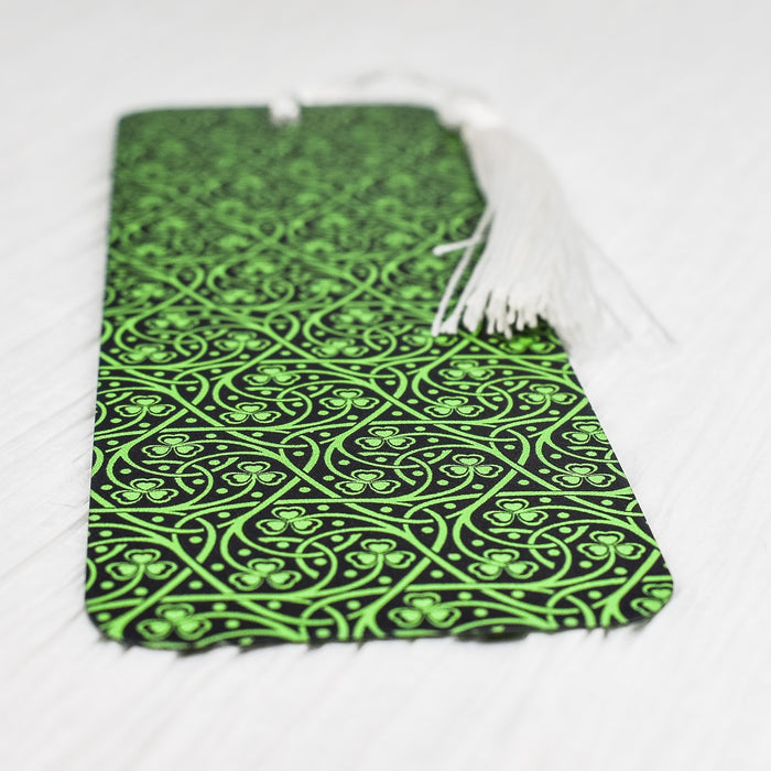 a green and black tie laying on a white surface