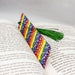 a bookmark with a green tassel on top of an open book