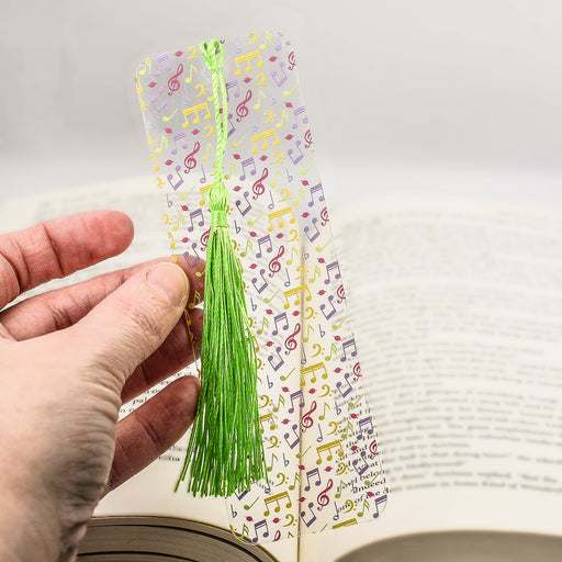 a hand holding a bookmark with musical notes on it