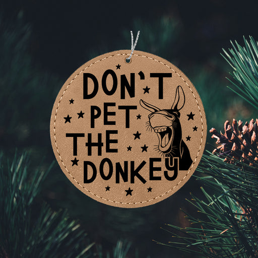 a wooden ornament that says don't pet the donkey
