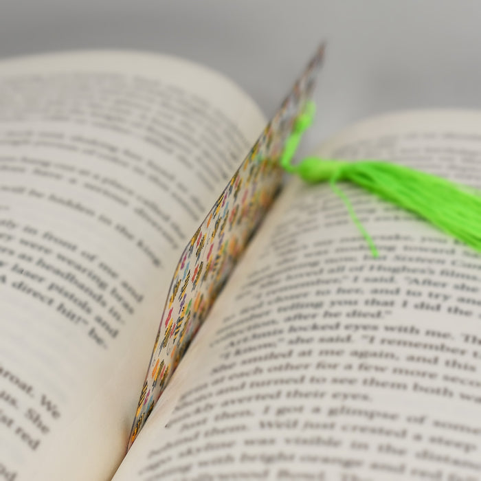 an open book with a green tassel on top of it