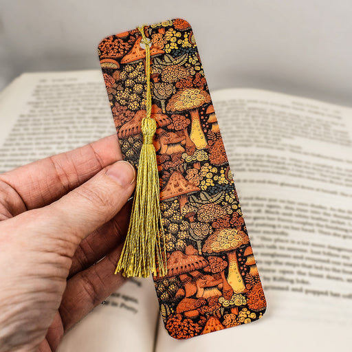 a hand holding a bookmark with a tassel
