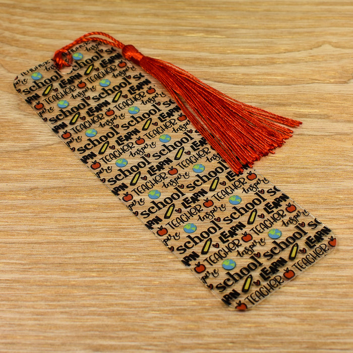 a bookmark with a tassel on top of a wooden table