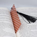 an open book with a tassel on top of it