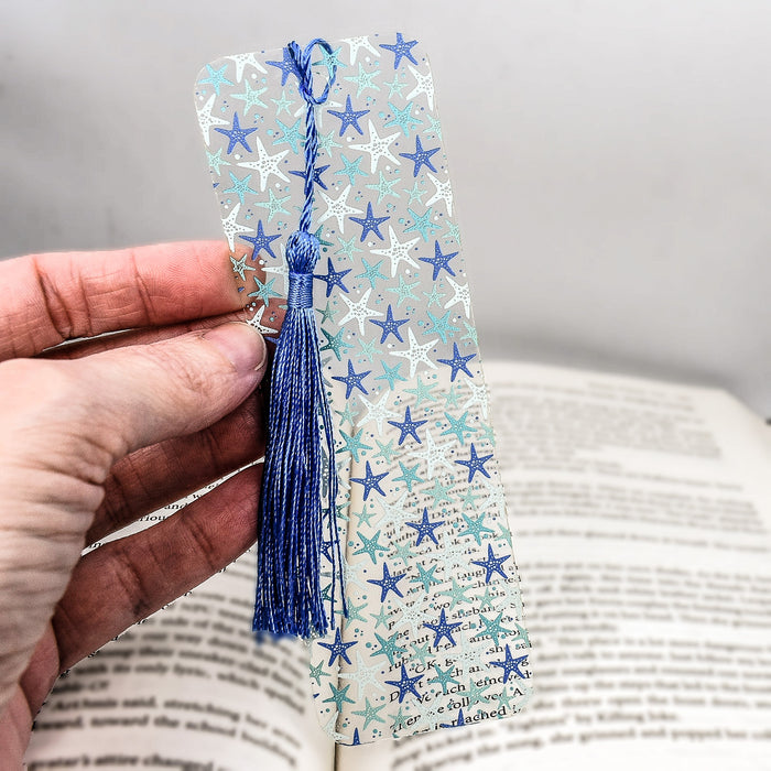 a hand holding a bookmark with blue and white stars on it